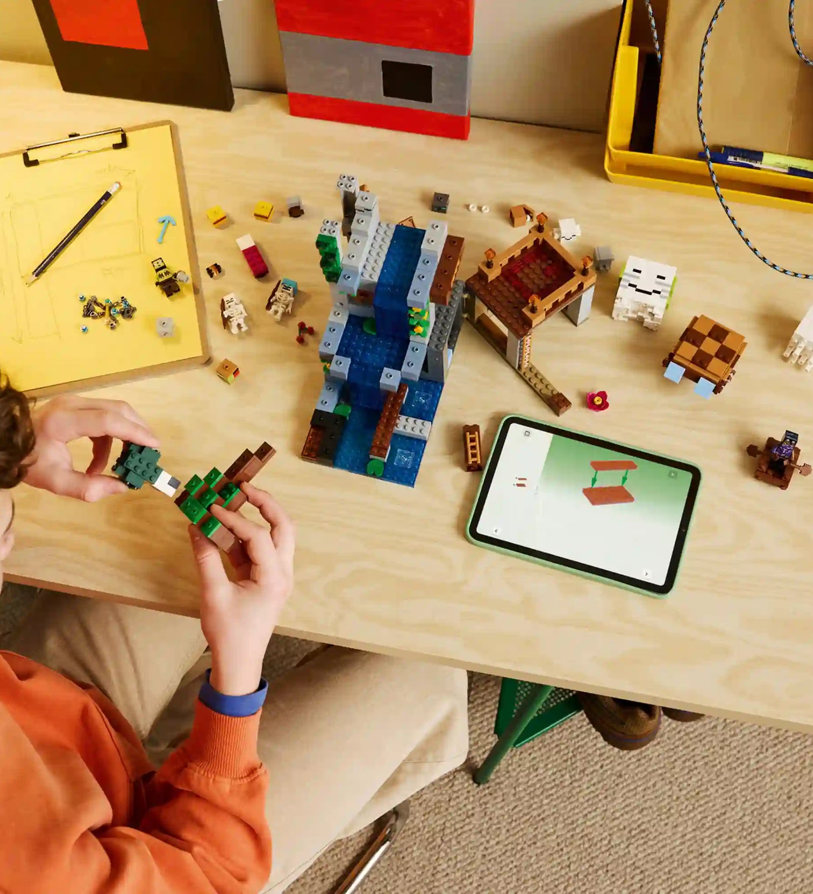 Gyermek építi a LEGO Minecraft Szellemkikötő (21597) készletet, miközben a LEGO Builder alkalmazás digitális útmutatója segíti az összeszerelést.