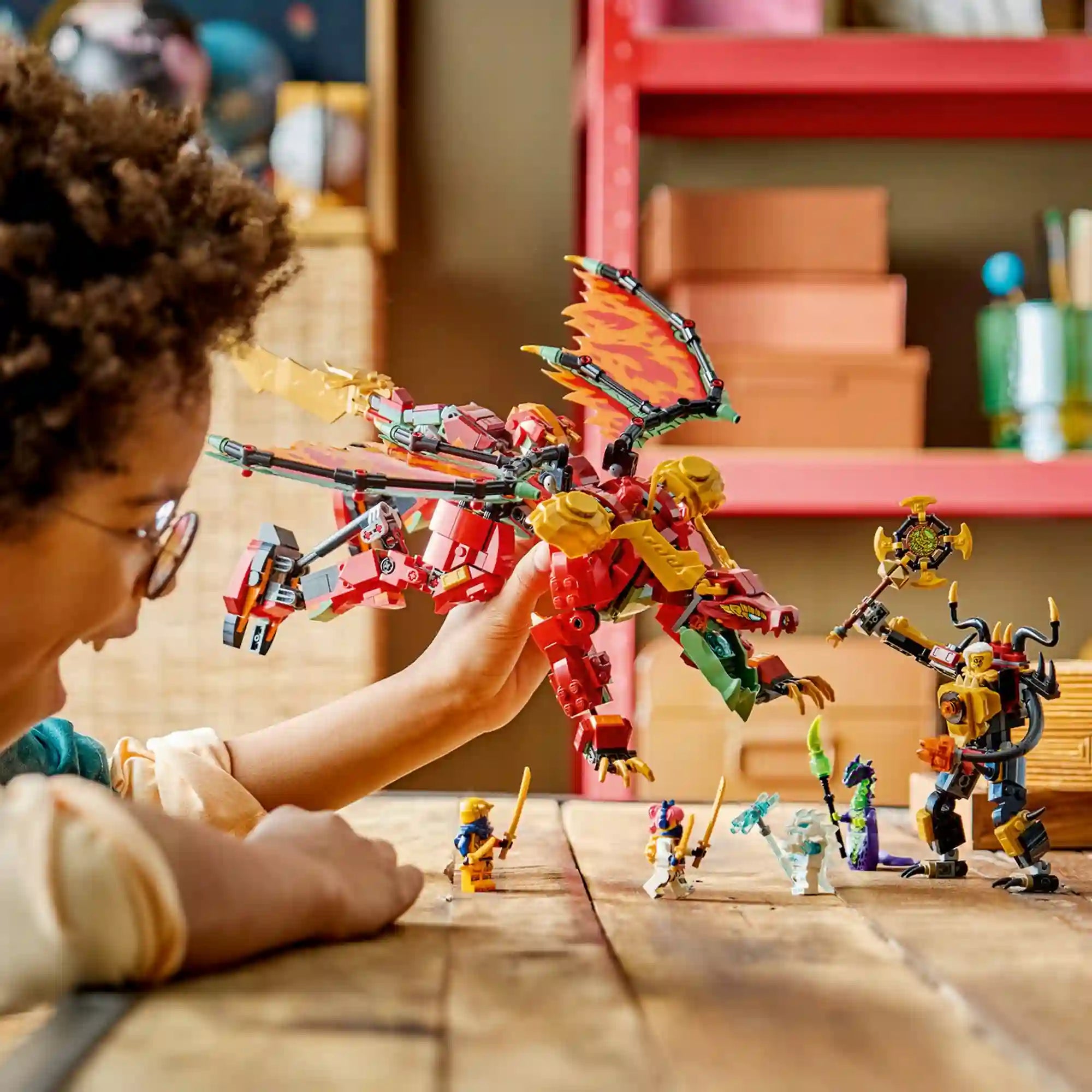Gyermek játszik a LEGO NINJAGO Wyldfyre átalakuló sárkányrobotja 71868 készlettel, miközben a sárkány és az ellenséges robot összecsapását jeleníti meg.