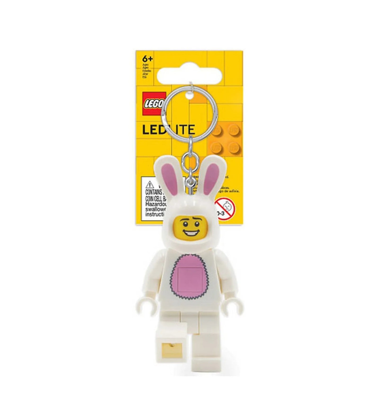 A LEGO Nyuszis minifigura LED kulcstartó csomagolva, sárga háttérlap előtt. A kulcstartón fehér nyuszijelmezbe bújt, mosolygós LEGO figura látható rózsaszín hassal és hosszú fülekkel.