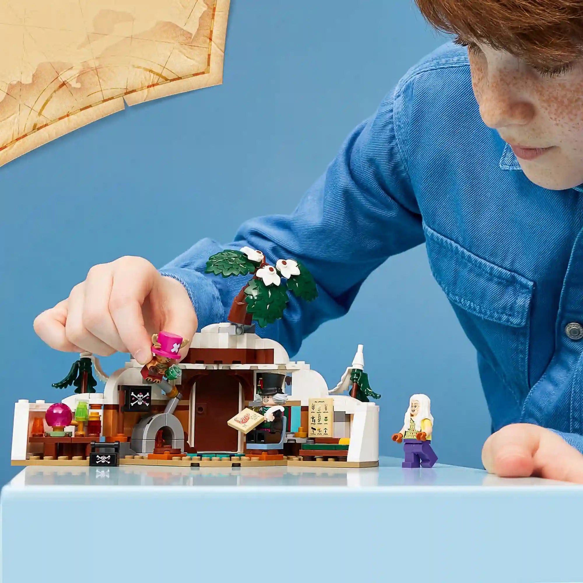 Gyermek játszik a LEGO One Piece: Dr. Hiriluk rejtekhelye 75641 készlettel, amely kinyitható barlangot és részletgazdag belső teret rejt.