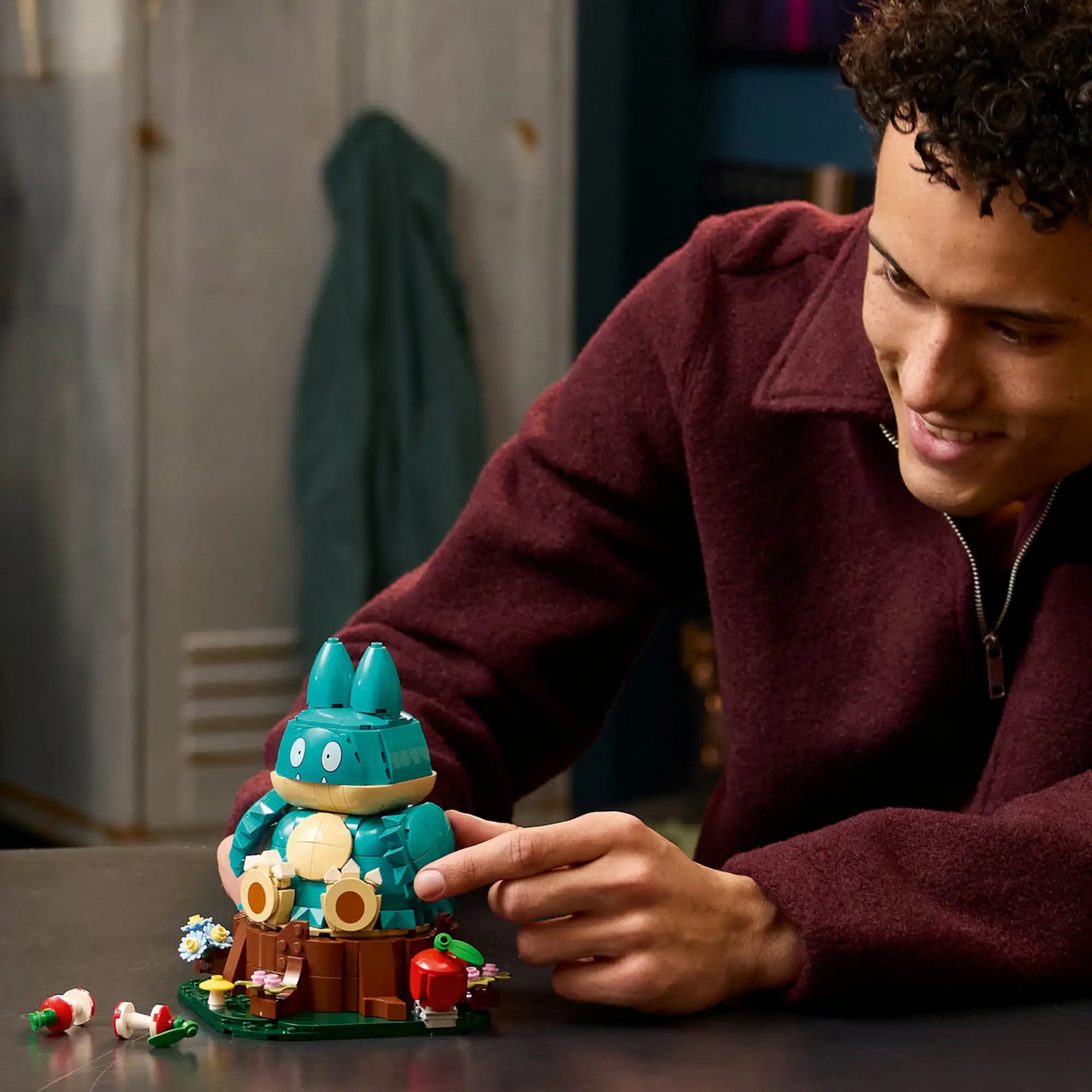 Egy építő a LEGO Pokémon Munchlax figurát állítja be a részletgazdag talapzaton.
