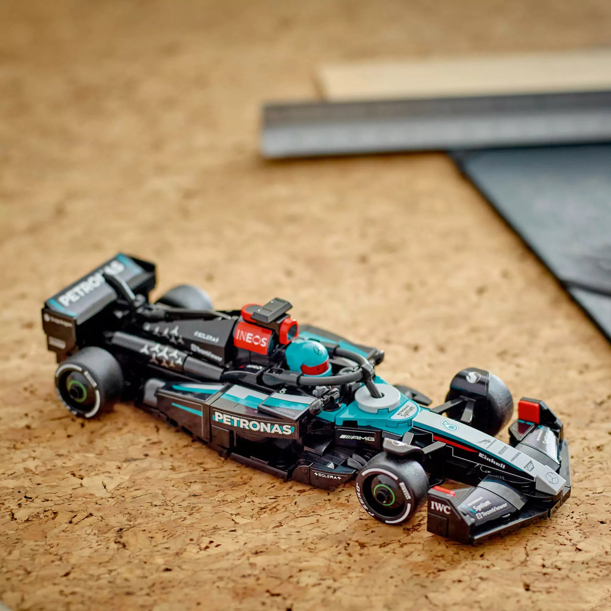  LEGO Speed Champions Mercedes-AMG F1 W15 versenyautó makett játék közben faasztalon.

