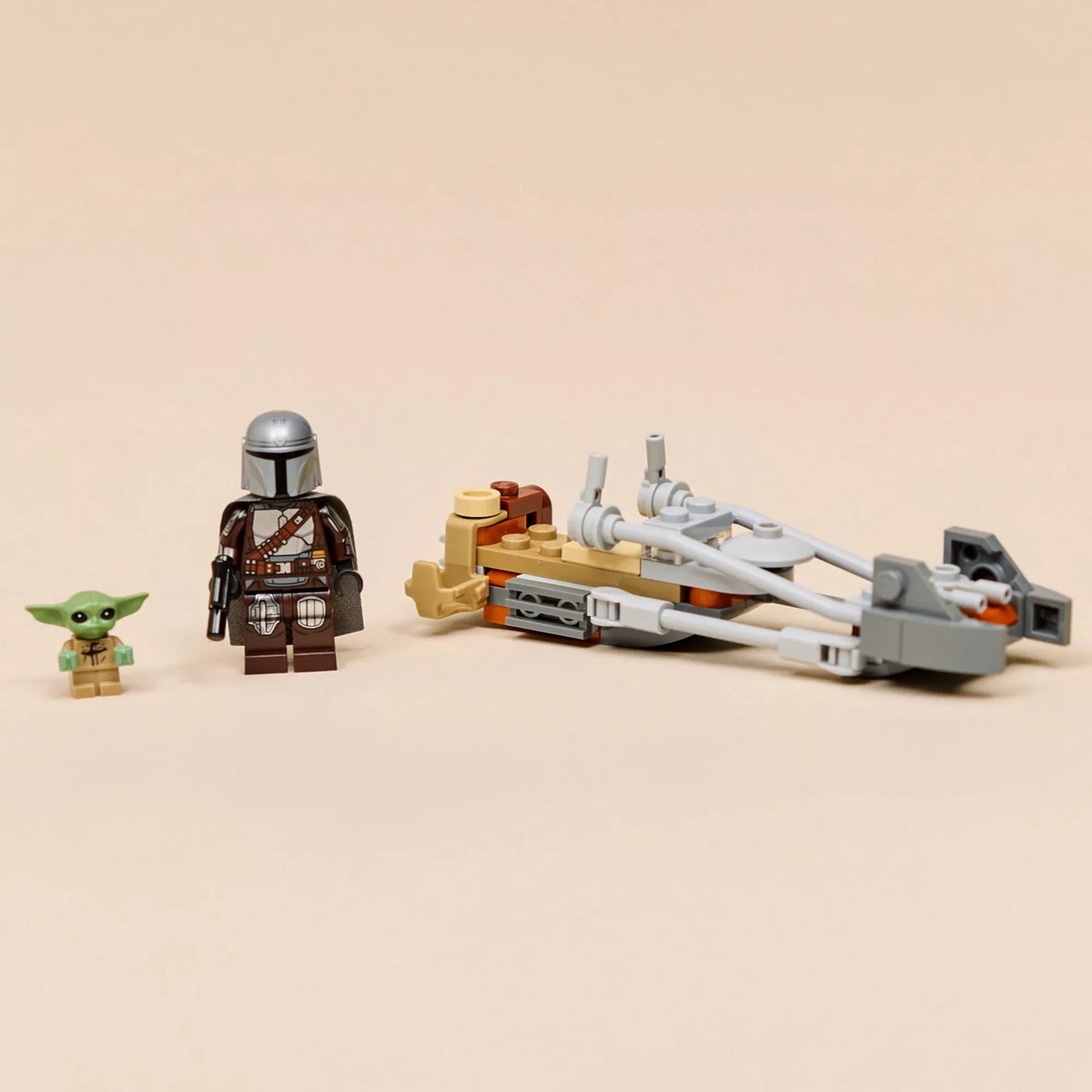 A LEGO Star Wars The Mandalorian & Grogu gyorsmotor (75436) teljes tartalma fehér háttéren: speeder bike modell, Mandalorian minifigura és Grogu figura.