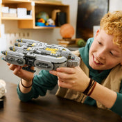 Gyerek LEGO Star Wars csillaghajót tart és játszik vele, részletes modell közelről