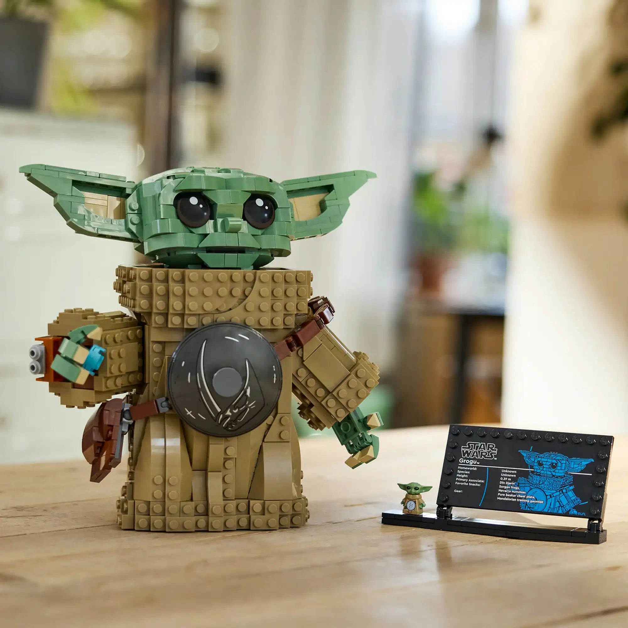 LEGO Star Wars: Grogu (Mandalóri tanonc) kész modell információs táblával és minifigurával, kiállításra helyezve.