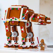 LEGO Star Wars: Mézeskalács AT-AT lépegető 40806 barna modellje színes cukorkadíszekkel, fényfüzérrel és Darth Vader figurával.