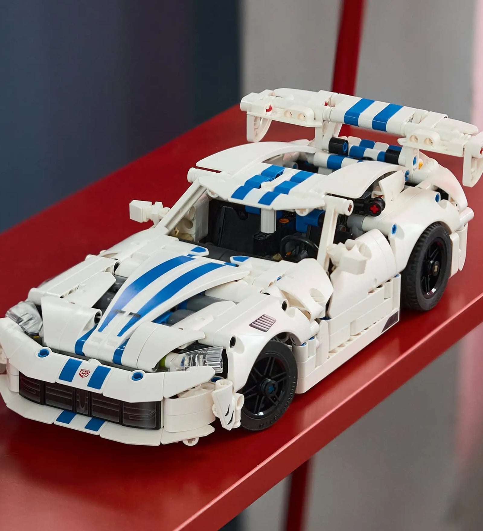 A LEGO Technic: Dodge Viper GTS-R sportautó 42234 megépített modellje piros polcon kiállítva.