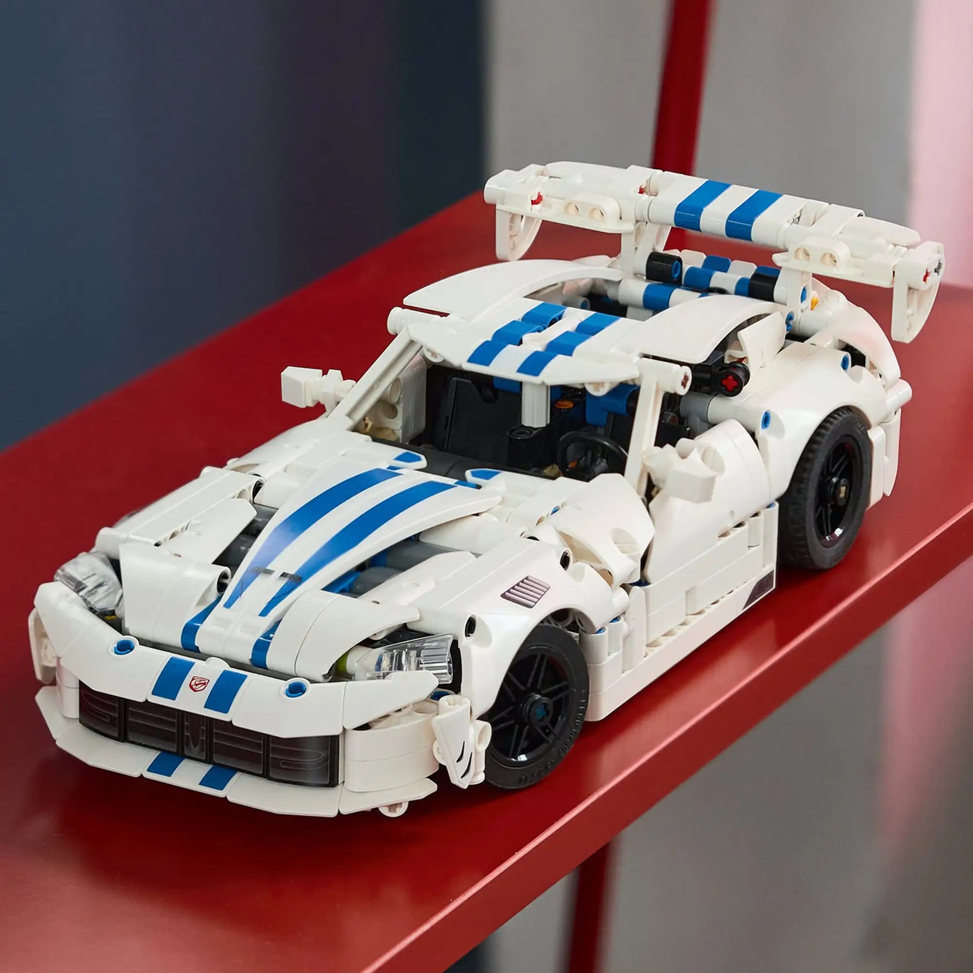 A LEGO Technic: Dodge Viper GTS-R sportautó 42234 megépített modellje piros polcon kiállítva.