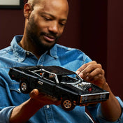 Felnőtt építő kezében a LEGO Technic Fast and Furious Dodge Charger R/T modell, amely bemutatja a készlet méretét és részletgazdagságát.