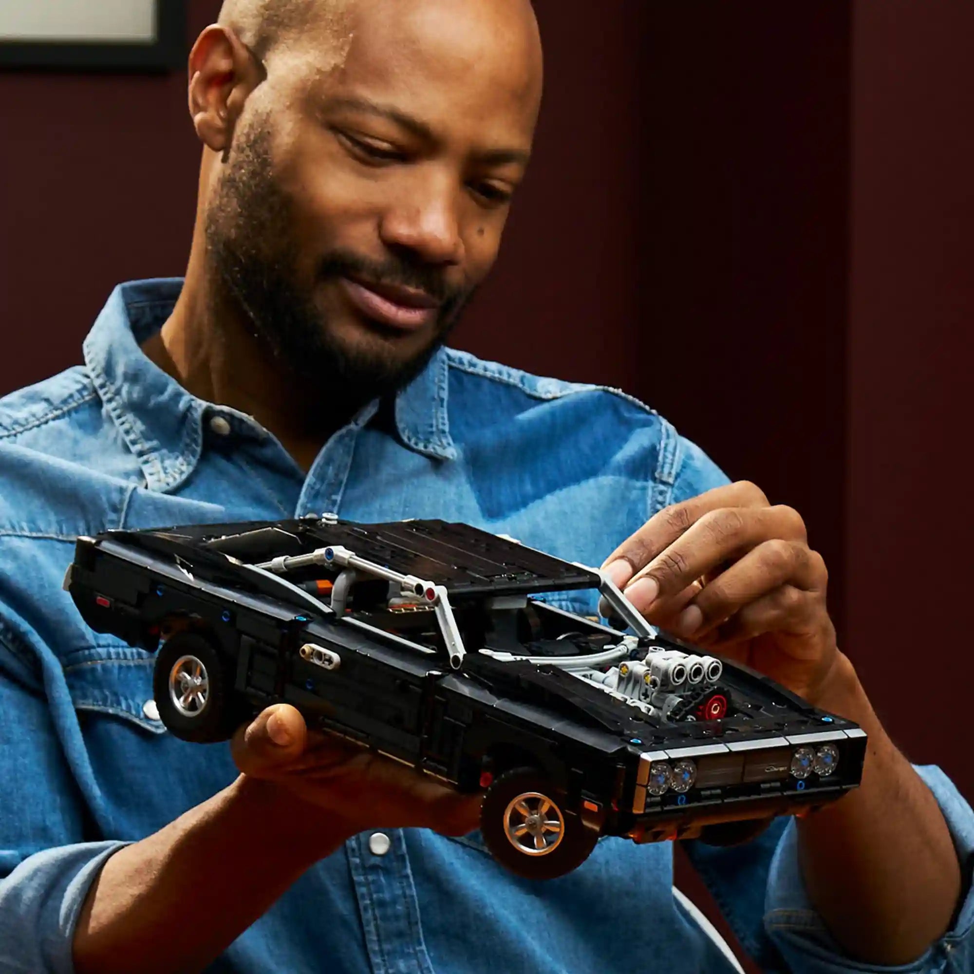 Felnőtt építő kezében a LEGO Technic Fast and Furious Dodge Charger R/T modell, amely bemutatja a készlet méretét és részletgazdagságát.