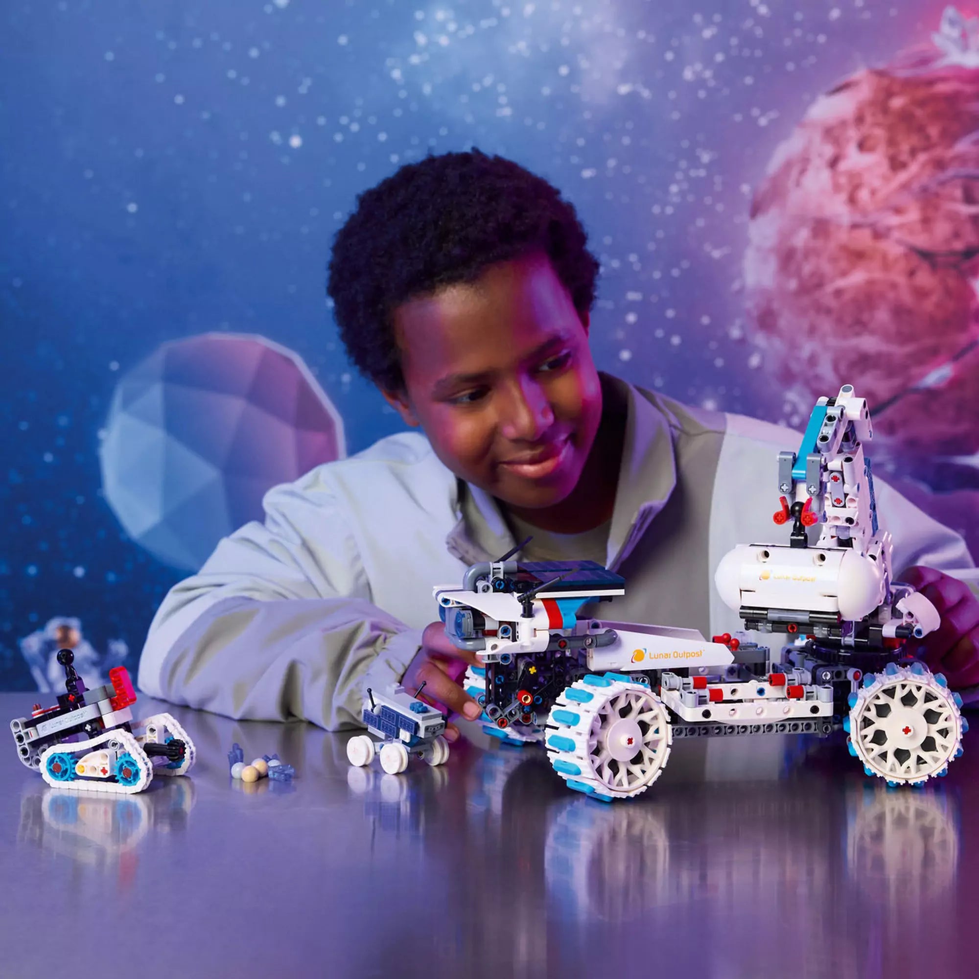 Gyerek játszik a LEGO Technic Lunar Outpost Holdjáró (42211) teljesen megépített járművével és a kis roverekkel.