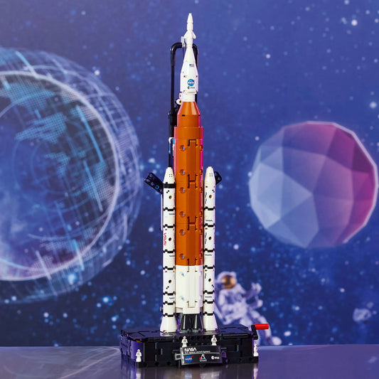 LEGO Technic: NASA Artemis rakétakilövő rendszer 42221 – Megépített Artemis rakéta kiállító talapzaton, űr témájú háttér előtt.