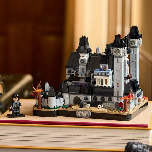 LEGO Wednesday: Nevermore Akadémia 76788 szürke-fekete kastélymodellje óratornyokkal és Wednesday minifigurájával, könyveken kiállítva.