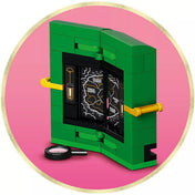 A LEGO Wicked – Emerald City & Kiamo Ko Castle (75689) térképes kiegészítője nagyítóval, rózsaszín háttéren.