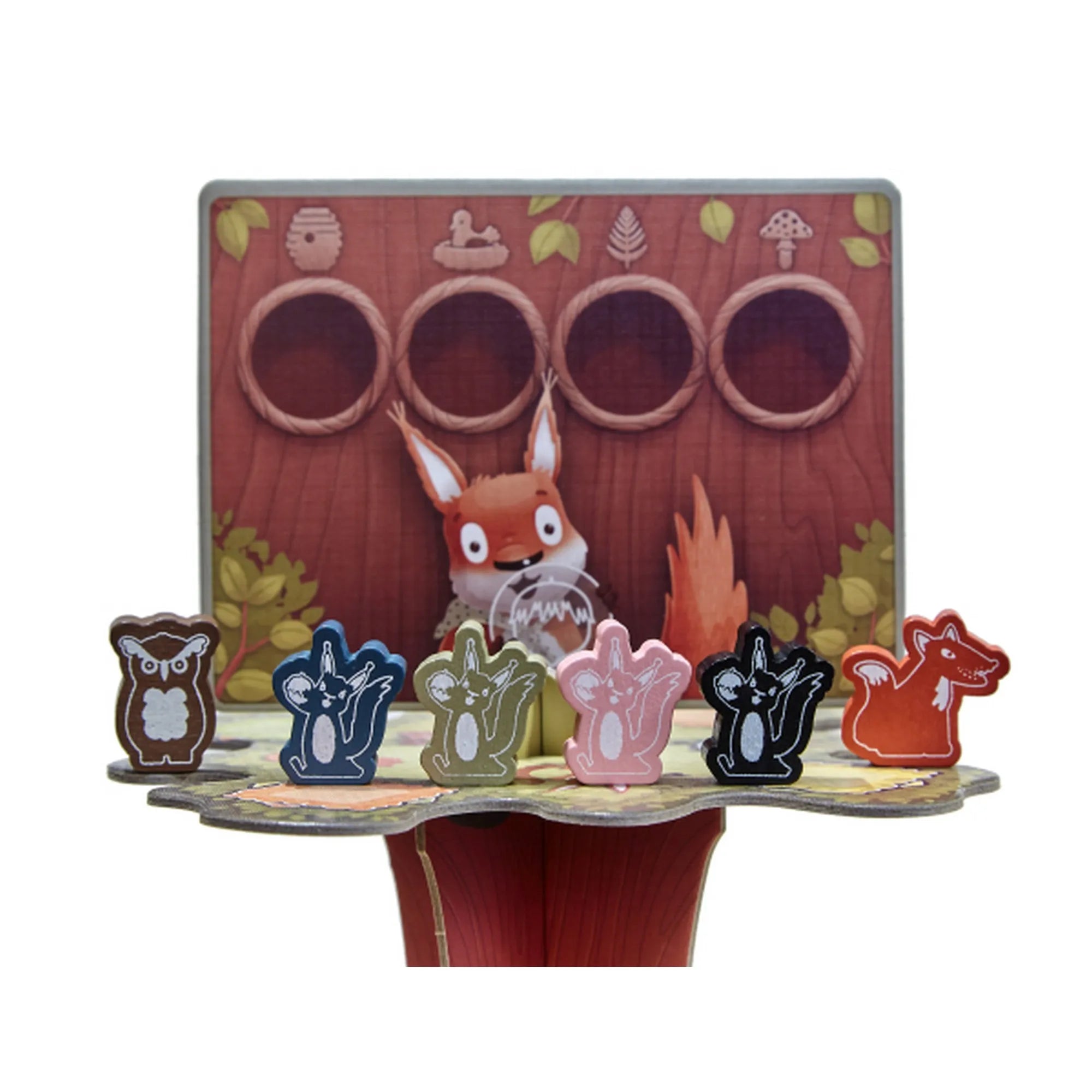 A Mókusfutam játékhoz tartozó mókus- és bagolyfigurák a felső játékszinten, mögöttük egy játékoskártya fatörzs mintával.