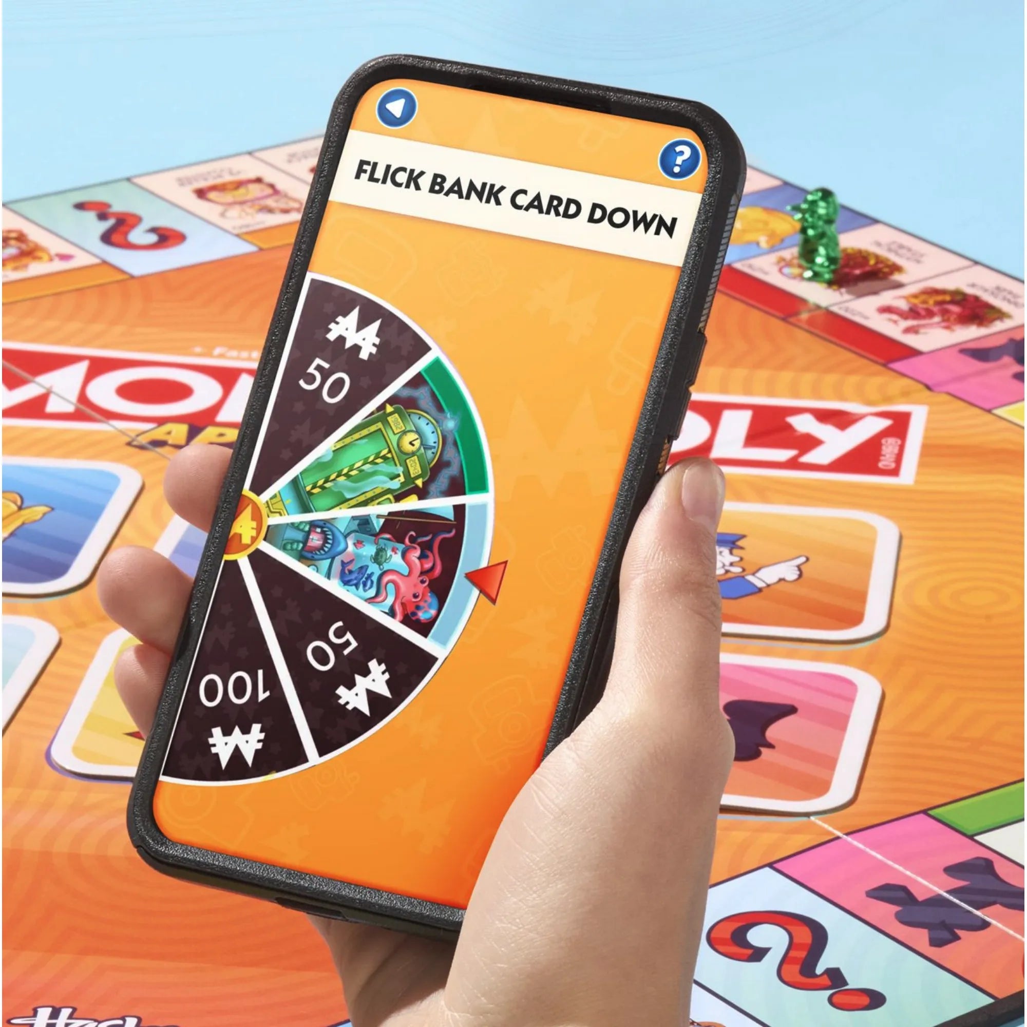 Monopoly App Banking társasjáték alkalmazása okostelefonon, mini játék képernyője a játéktábla felett.