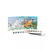 A Moulin Roty Számozott festőkészlet tartalma: két festőlap – egyik kiszínezve, másik számozott vonalrajzként –, előttük sorban elhelyezett 16 tégely festék és két ecset. A jelenet egy rókacsaládot ábrázol virágos réten, élénk színekkel.