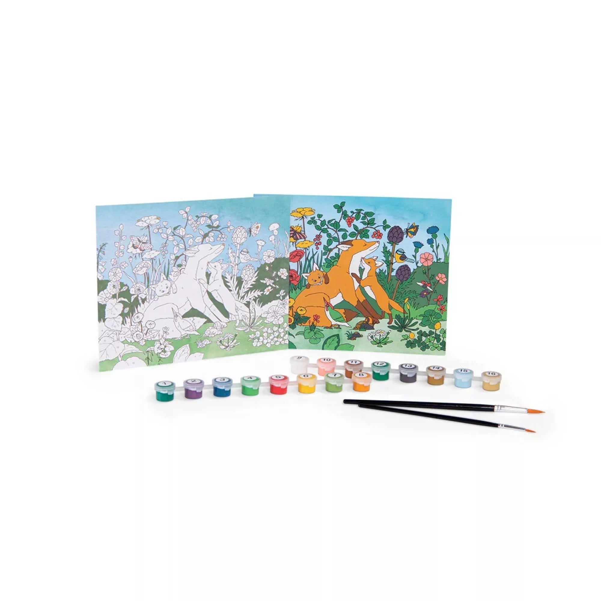 A Moulin Roty Számozott festőkészlet tartalma: két festőlap – egyik kiszínezve, másik számozott vonalrajzként –, előttük sorban elhelyezett 16 tégely festék és két ecset. A jelenet egy rókacsaládot ábrázol virágos réten, élénk színekkel.