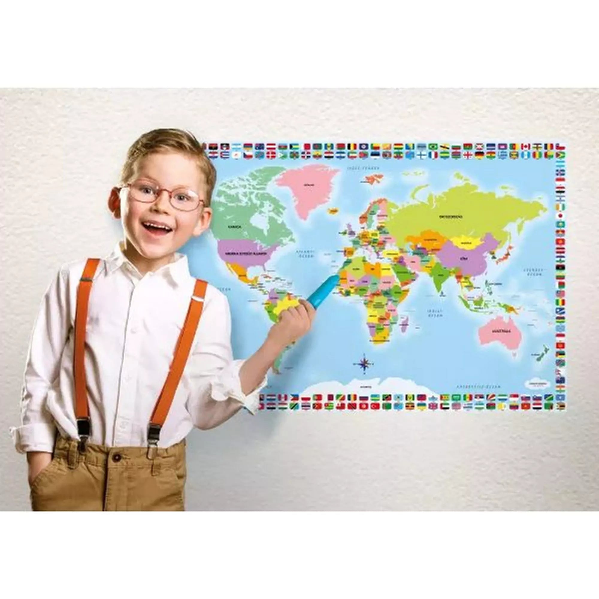 Mosolygó kisfiú mutat a My Map Pro interaktív világtérképre az intelligens tollal, tanulás játék közben.