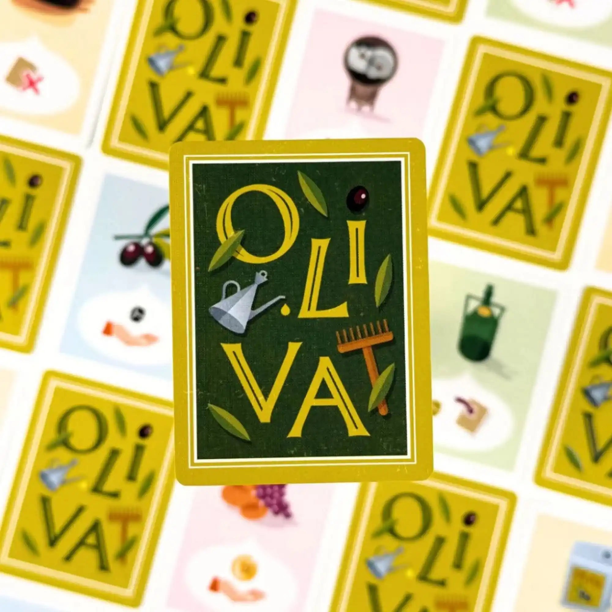 Az Oliva társasjáték egyik hátoldali kártyája „OLIVA” felirattal, háttérben különféle akció- és termeléskártyákkal.