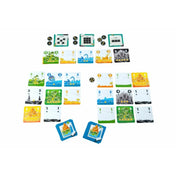 Papírvilág társasjáték: leterített játéktér sokféle zöld, kék, sárga és fekete tematikus kártyával, valamint jutalomkorongokkal.