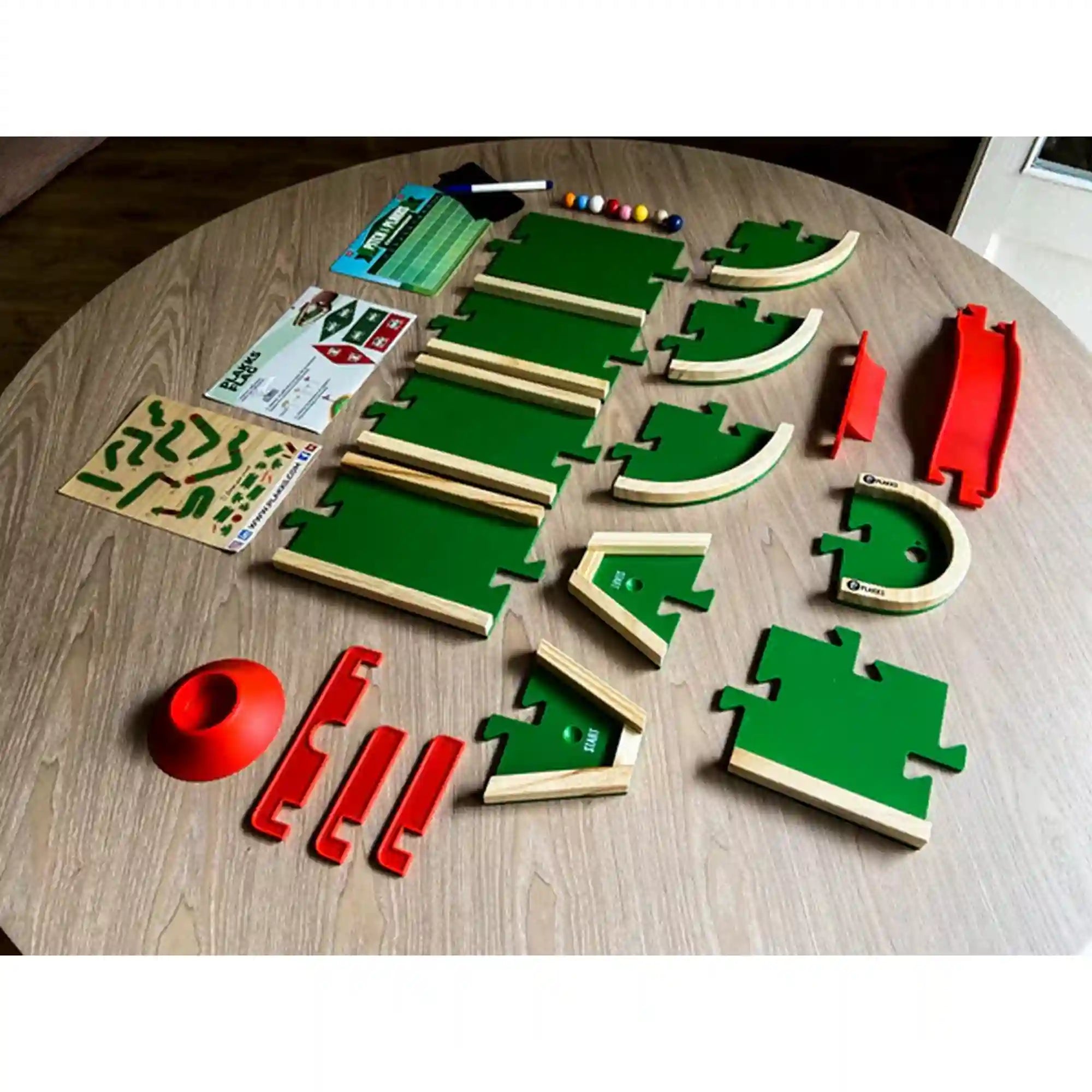 A Pitch&Plakks mini golf társasjáték teljes tartalma: moduláris pályaelemek, akadályok, labdák, pontozólap és kiegészítők.