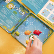 Smart Games Fish Tricks logikai játék kinyitott fémdobozban, elrendezett mágneses halakkal és nyitott feladványfüzettel.