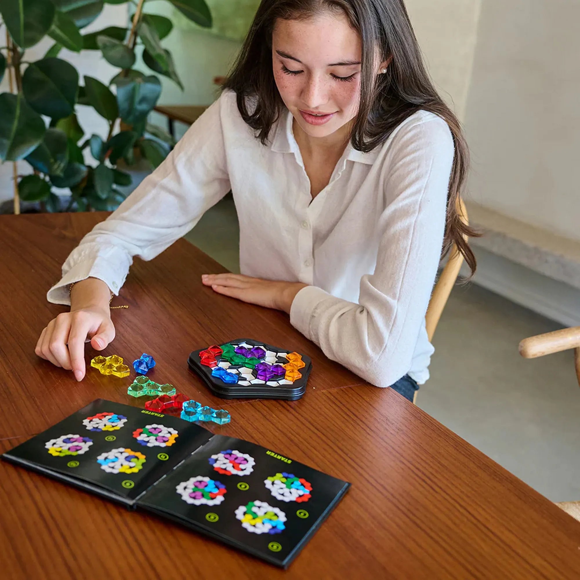 IQ Pentagon logikai játék használat közben, játékos a feladatfüzet alapján helyezi el a színes elemeket.