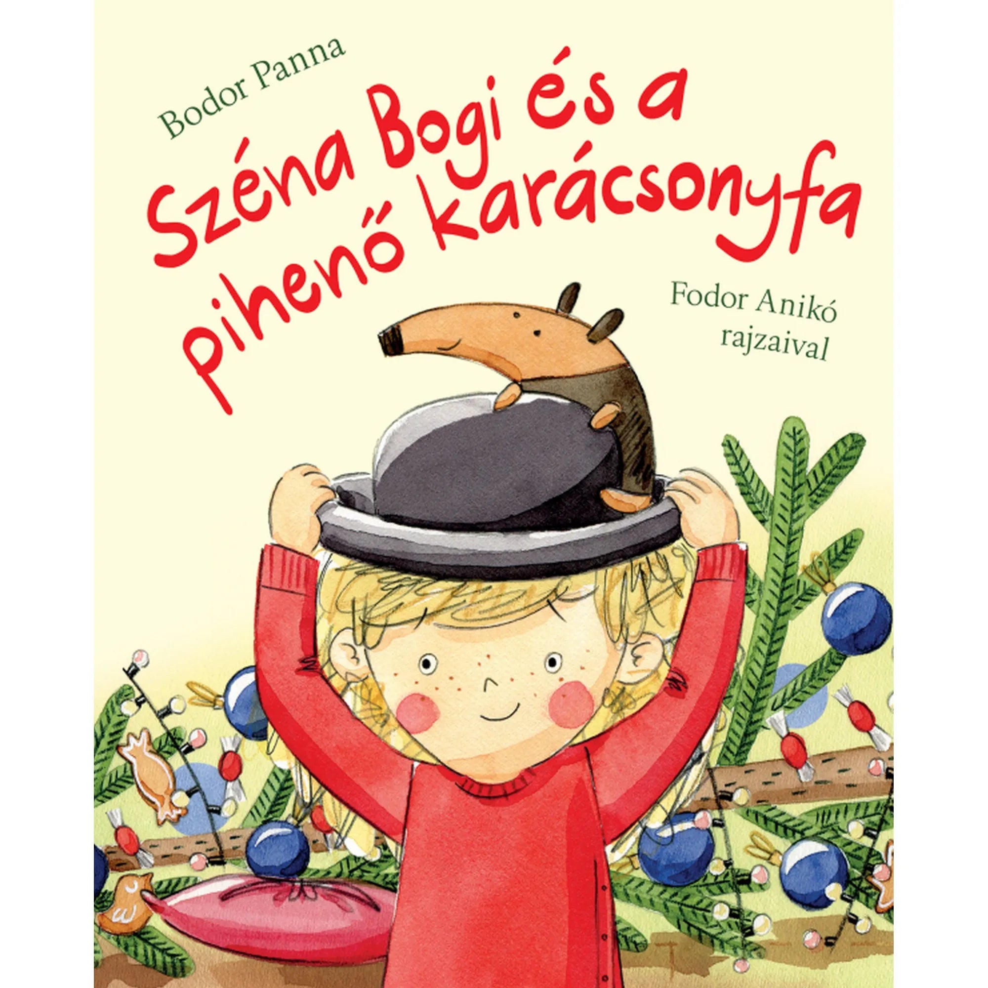 A „Széna Bogi és a pihenő karácsonyfa” című könyv borítója: egy mosolygós kisgyermek piros pulóverben kalapot tart a fején, amelyen egy kedves kis hangyaorrú állat ül. A háttérben karácsonyi díszek és fenyőágak láthatók, ünnepi, vidám hangulatot árasztva.